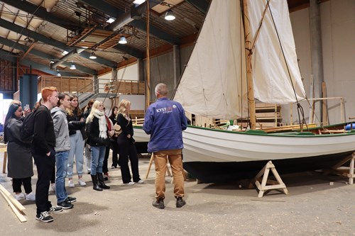 Under rundvisningen på Kystliv fortalte Ture Møller om, hvordan bådende er bygget af elever fra blandt andet 10. klassecenteret i Holbæk.